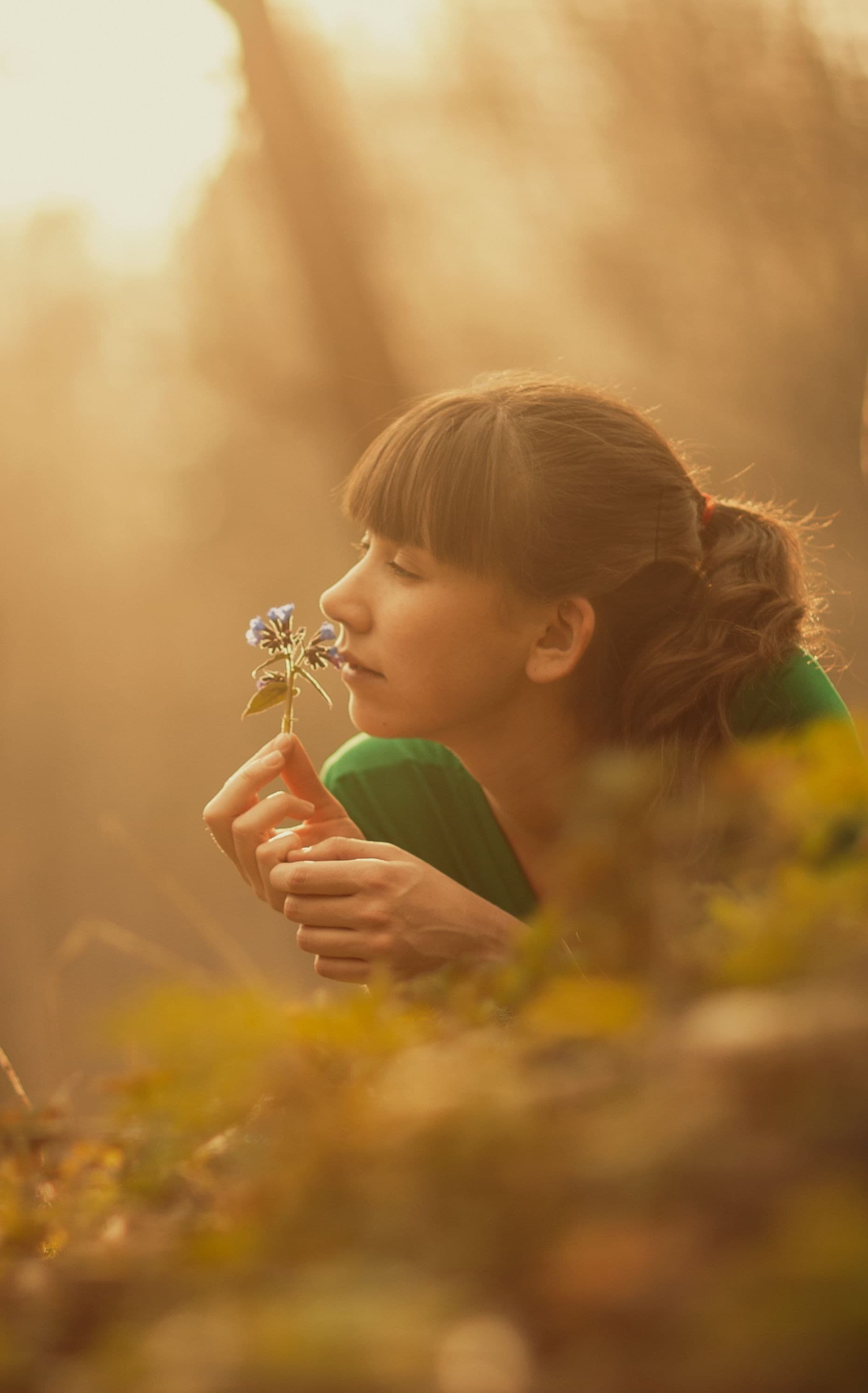 A woman experiencing nature, close to a wildflower